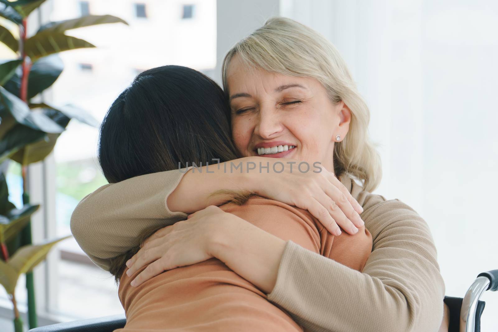 Close up Happy smiling face, a Caucasian senior woman hugging Asian granddaughter. Together, family mix, skin, love, sharing time, care, Mother and daughter, stepmother or stepdaughter concept