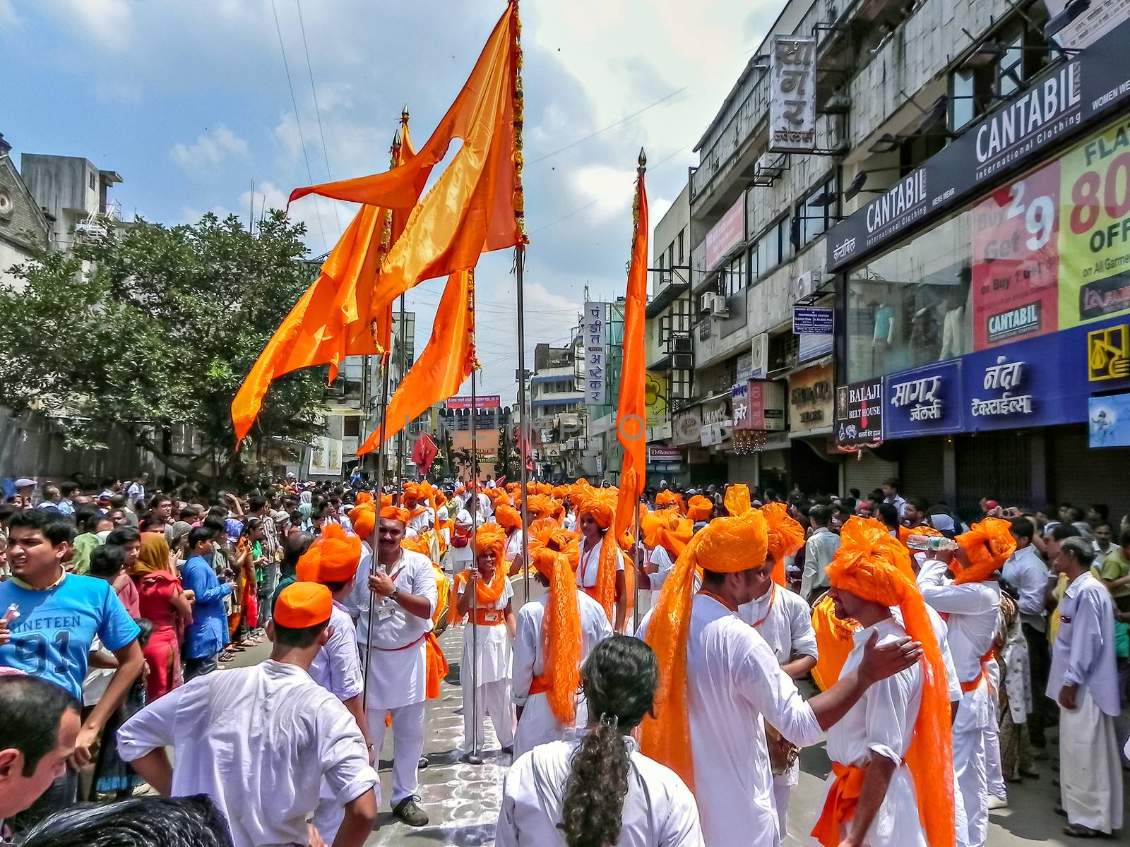Pune,Maharashtra,India-September 22nd,2010: Group of youths bearing traditional huge orange flags collectively marching during Ganapati procession.