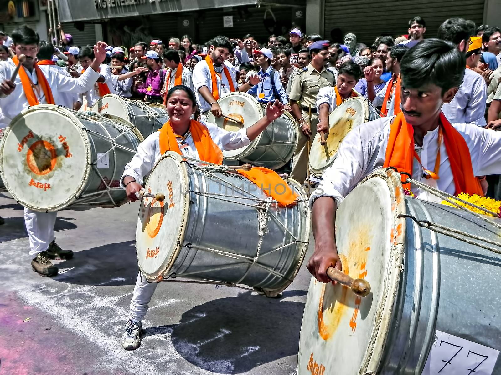 Pune,Maharashtra,India-September 22nd,2010:Group of young boys & girls, beating traditional dhol & tasha collectively during festival procession of ganesh as people in crowd watch.