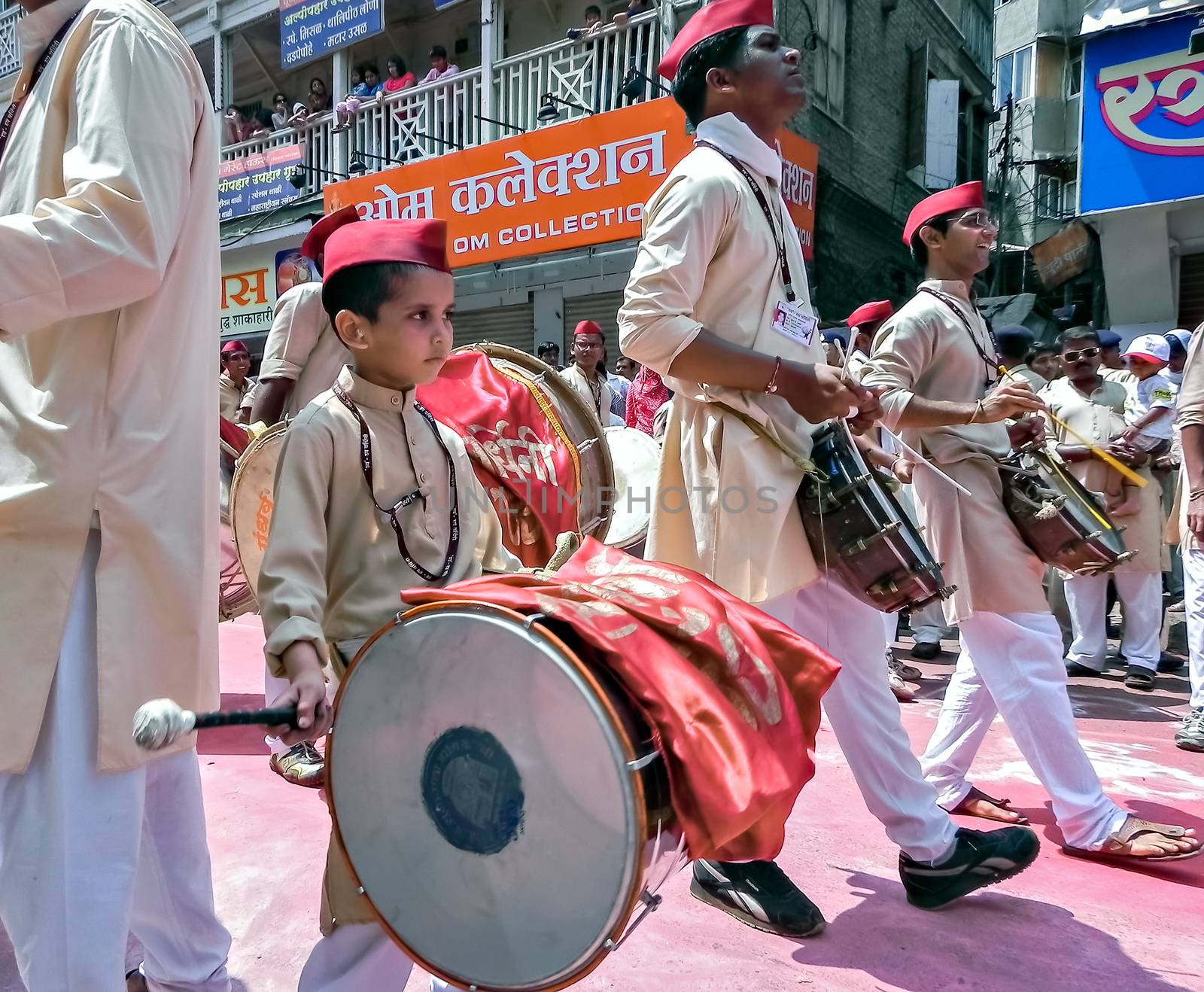 Pune,Maharashtra,India-September 22nd,2010:Little boy with red cap , with elder boys, beating huge traditional dhol during festival procession of ganesh.