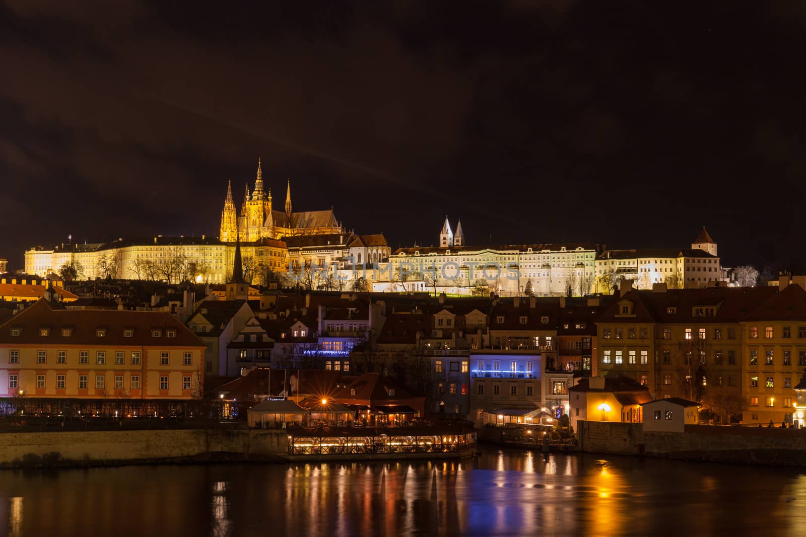 Beautiful night view of the light illuminated Prague Castle and St. Vitus Cathedral in Mala Strana old town by Vltava River from Charles Bridge, Prague, Czech Republic