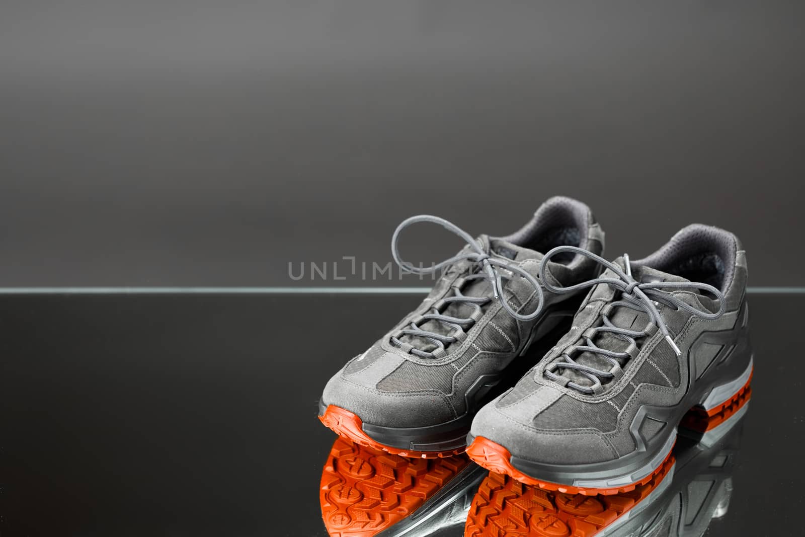 trekking sneakers with red sole, gray background with copy-space by nikkytok