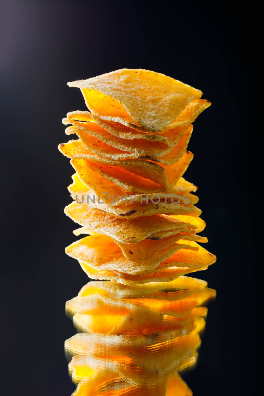 mexican nachos tortilla chips stack, black background by nikkytok