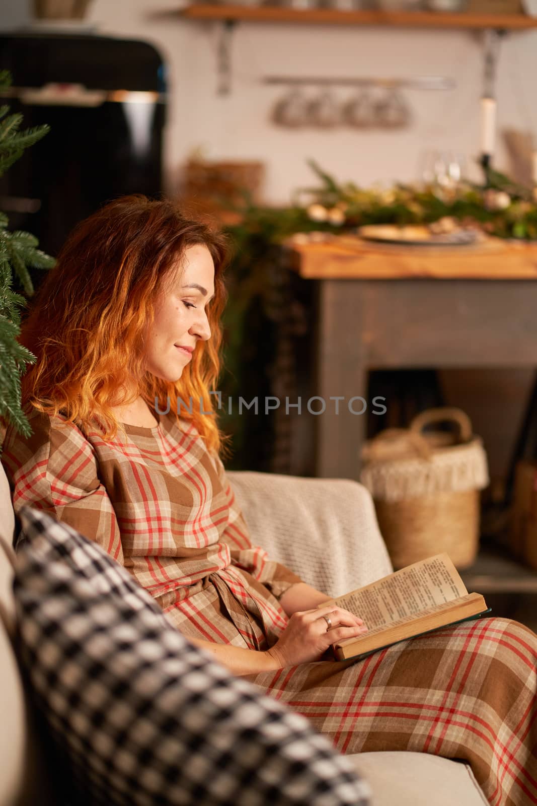 A cute girl is reading a book in a warm and cozy atmosphere. Relaxation and privacy concept.