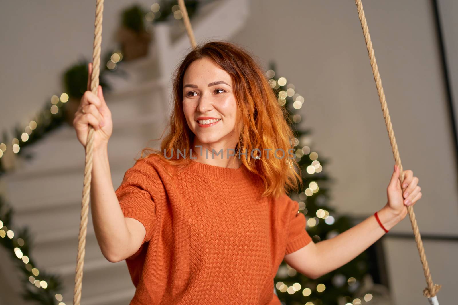 A beautiful redhead girl is swinging in her room on Christmas night.
