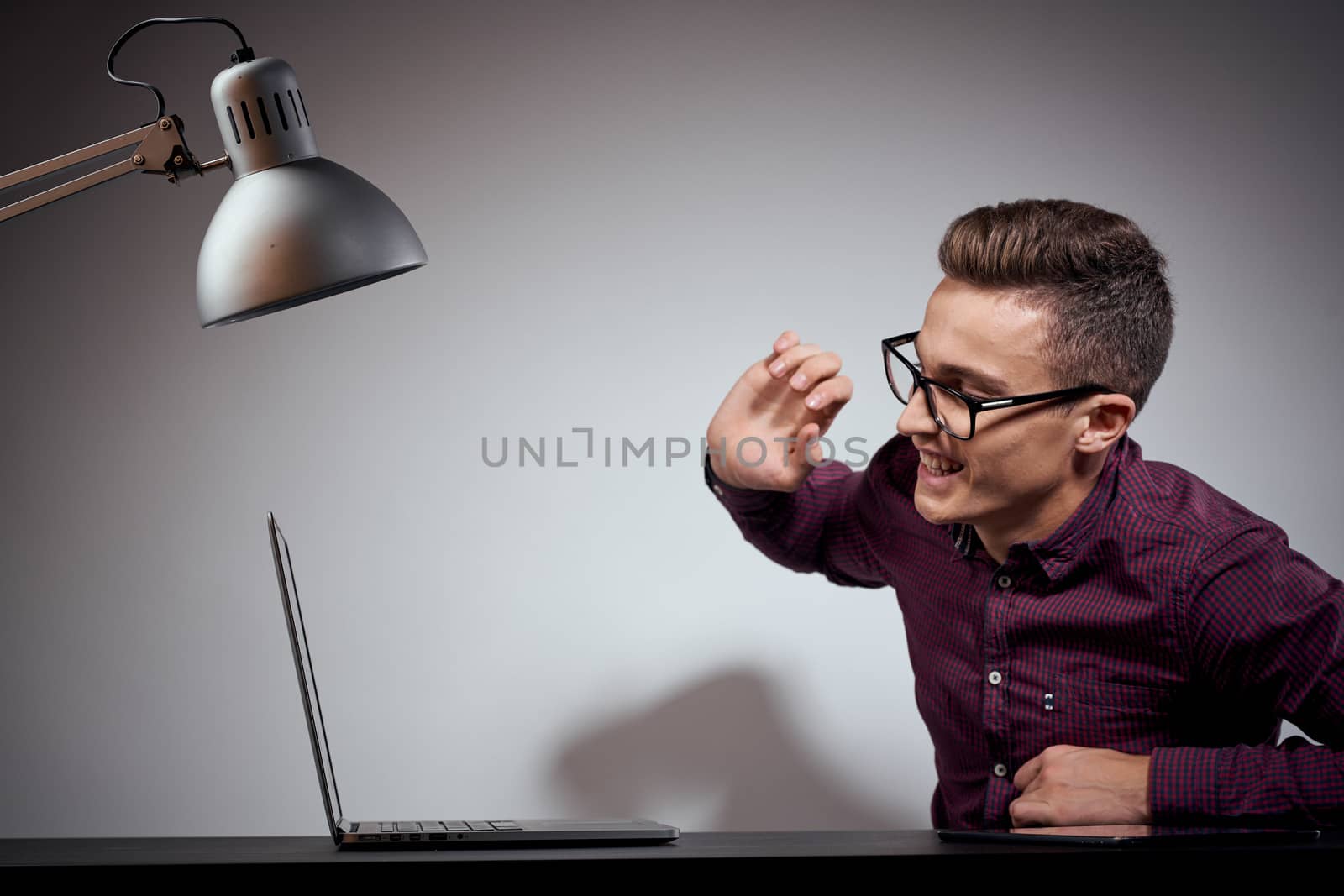 businessman in glasses and a shirt sits at a table with open laptops Coffee Space mobile phone. High quality photo
