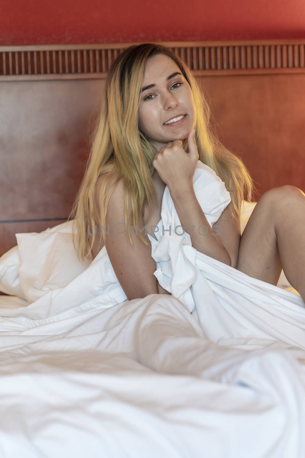 A gorgeous blonde model poses nude in a home environment