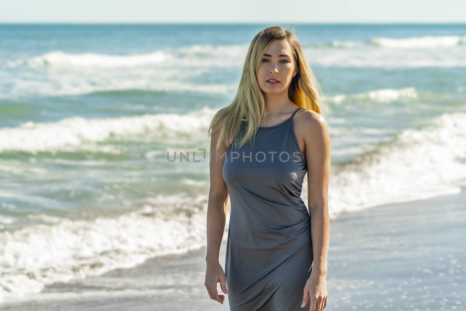 A gorgeous young blonde female enjoys a day at the beach alone