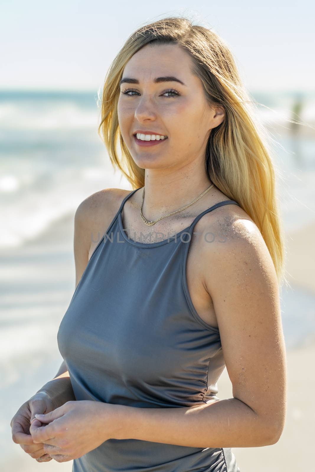 A gorgeous young blonde female enjoys a day at the beach alone