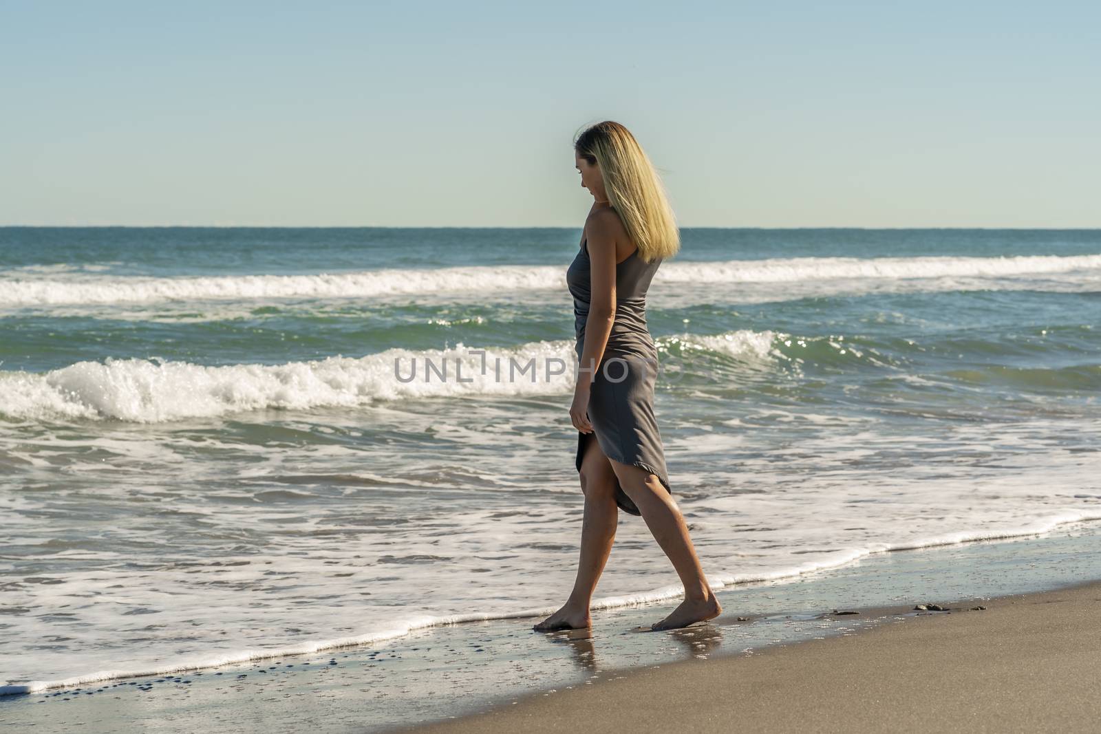 A gorgeous young blonde female enjoys a day at the beach alone