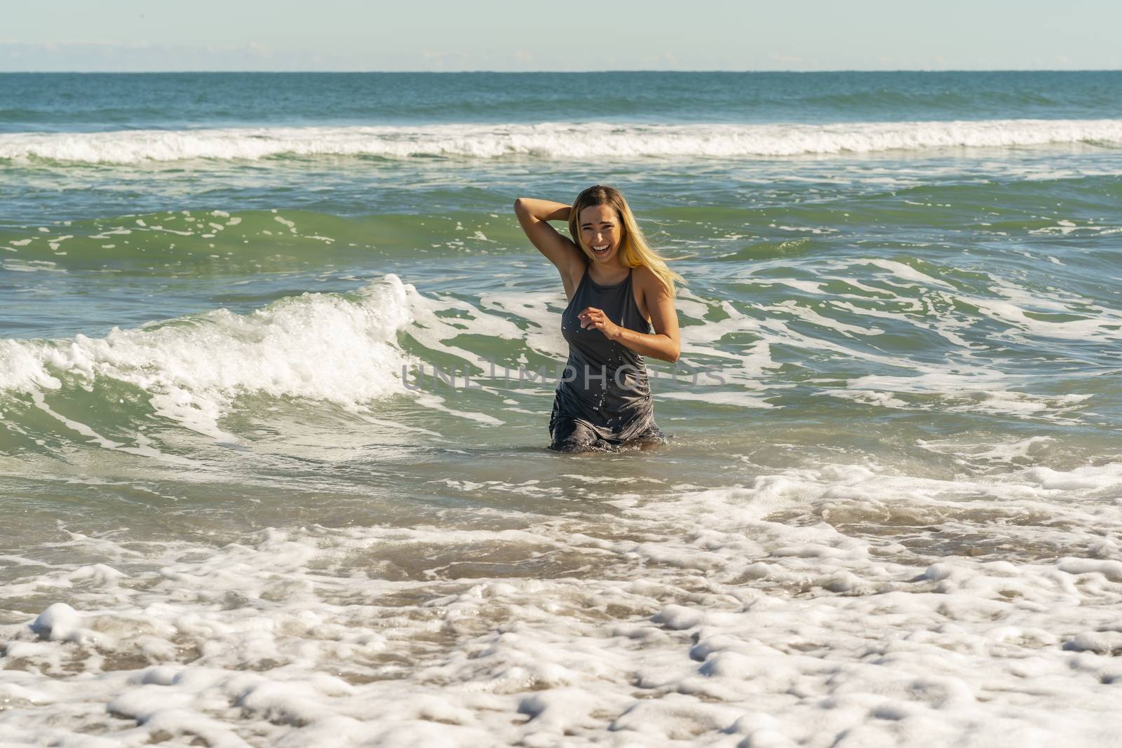 A gorgeous young blonde female enjoys a day at the beach alone