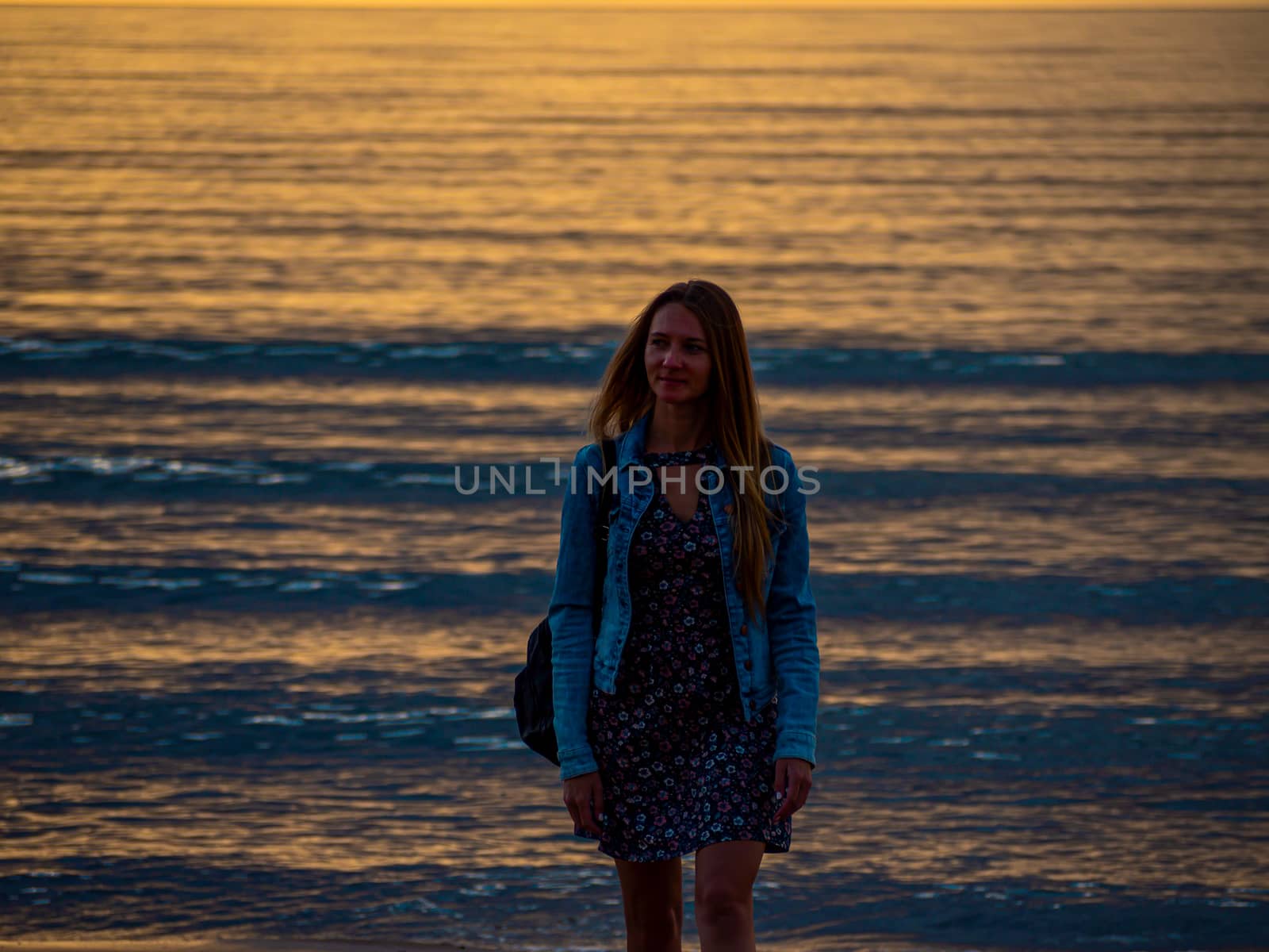 beautiful alone girl on the beach. Girl looking at stormy sea amd taking a picture with smarphone. The spectacular Storm with rain Is Coming in Estonia. Baltic sea