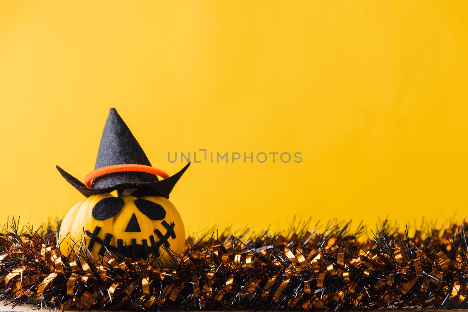 Funny Halloween day decoration party, halloween pumpkin head jack o lantern smile on shining, studio shot isolated yellow background, Happy holiday concept