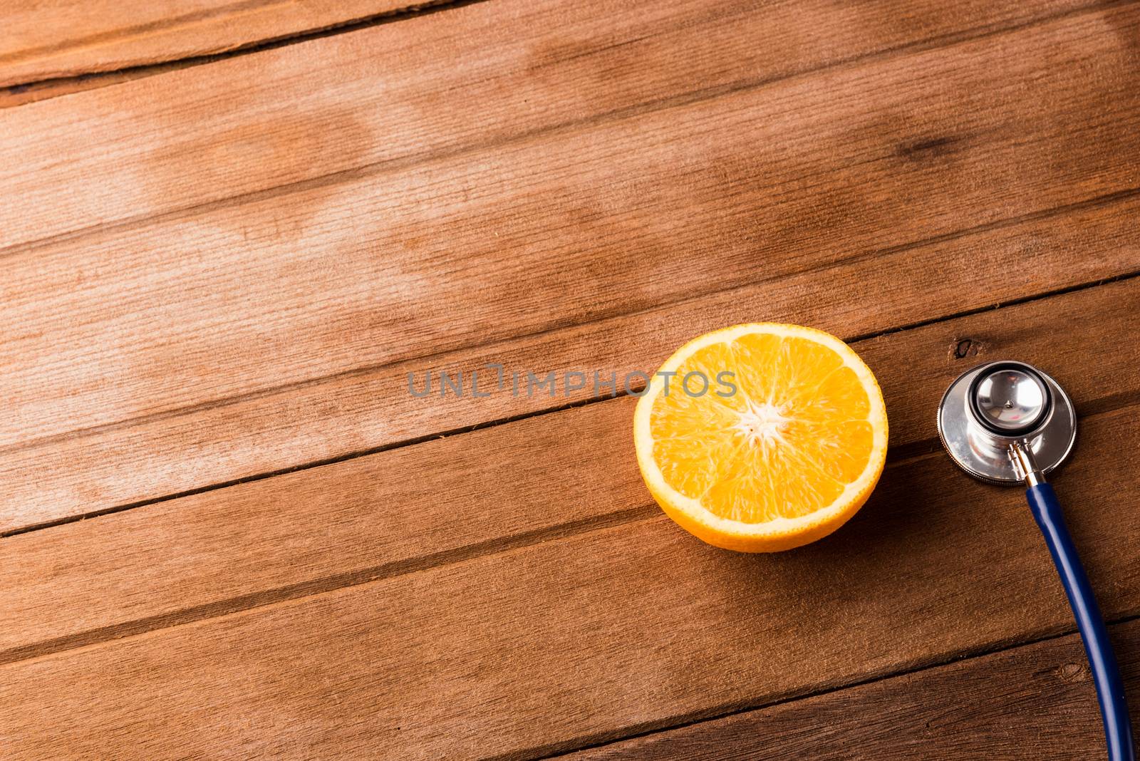 Orange fruit and Doctor stethoscope on wooden table, Vitamin C, Healthy lifestyle diet food concept