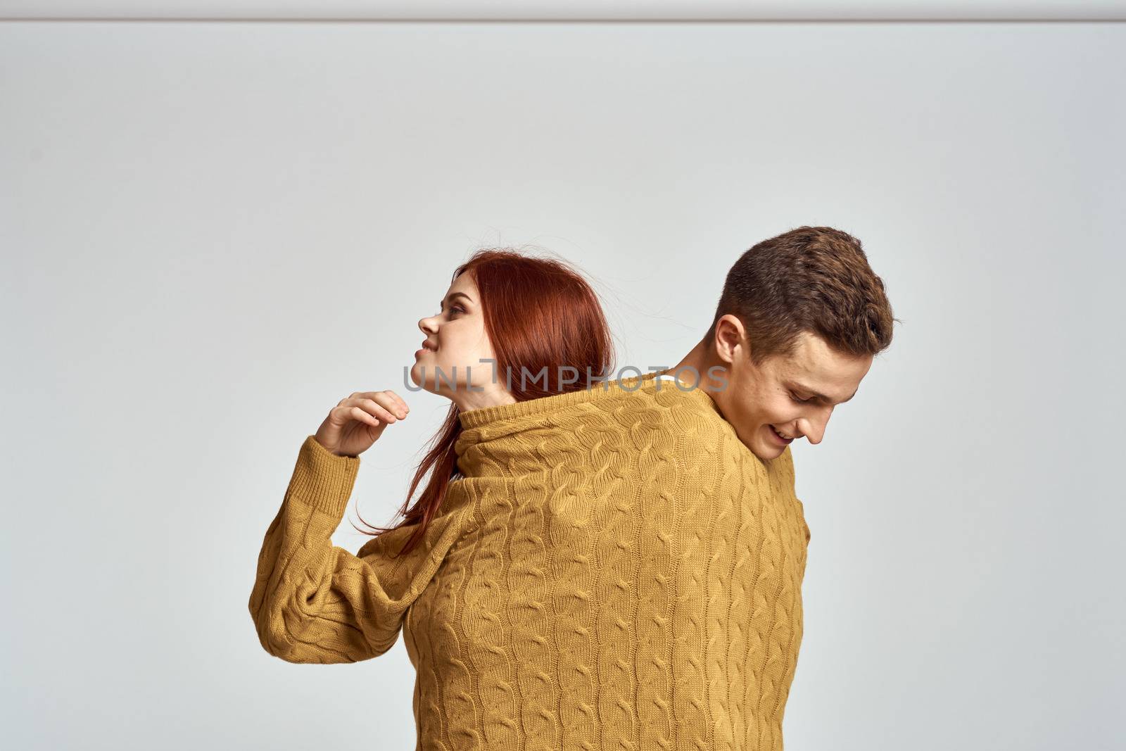 couple in yellow sweater posing against light background cropped view. High quality photo