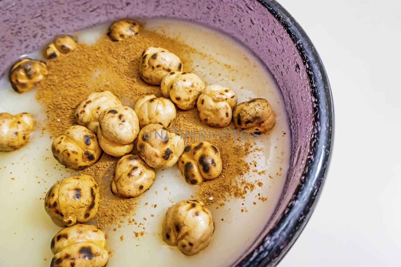 traditional turkish drink boza in glass with cinnamon powder and roasted chickpeas by yilmazsavaskandag