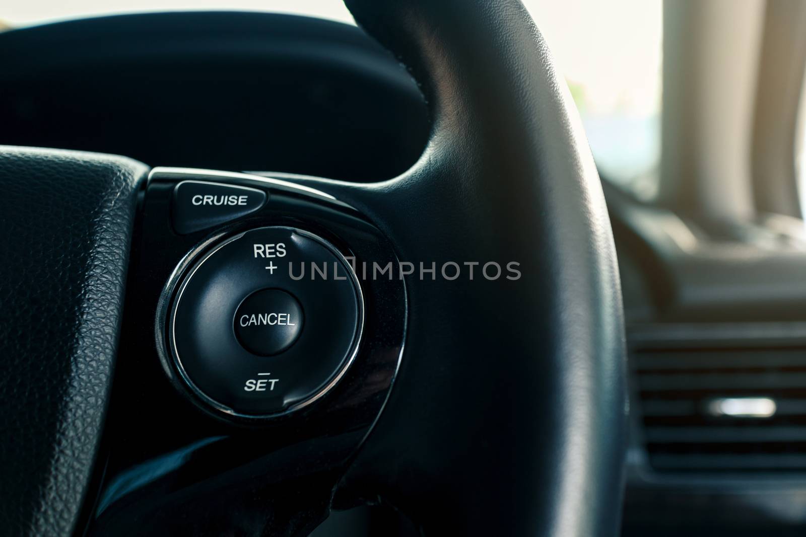 cruise control or speed control system on steering wheel in modern car, shallow depth of field