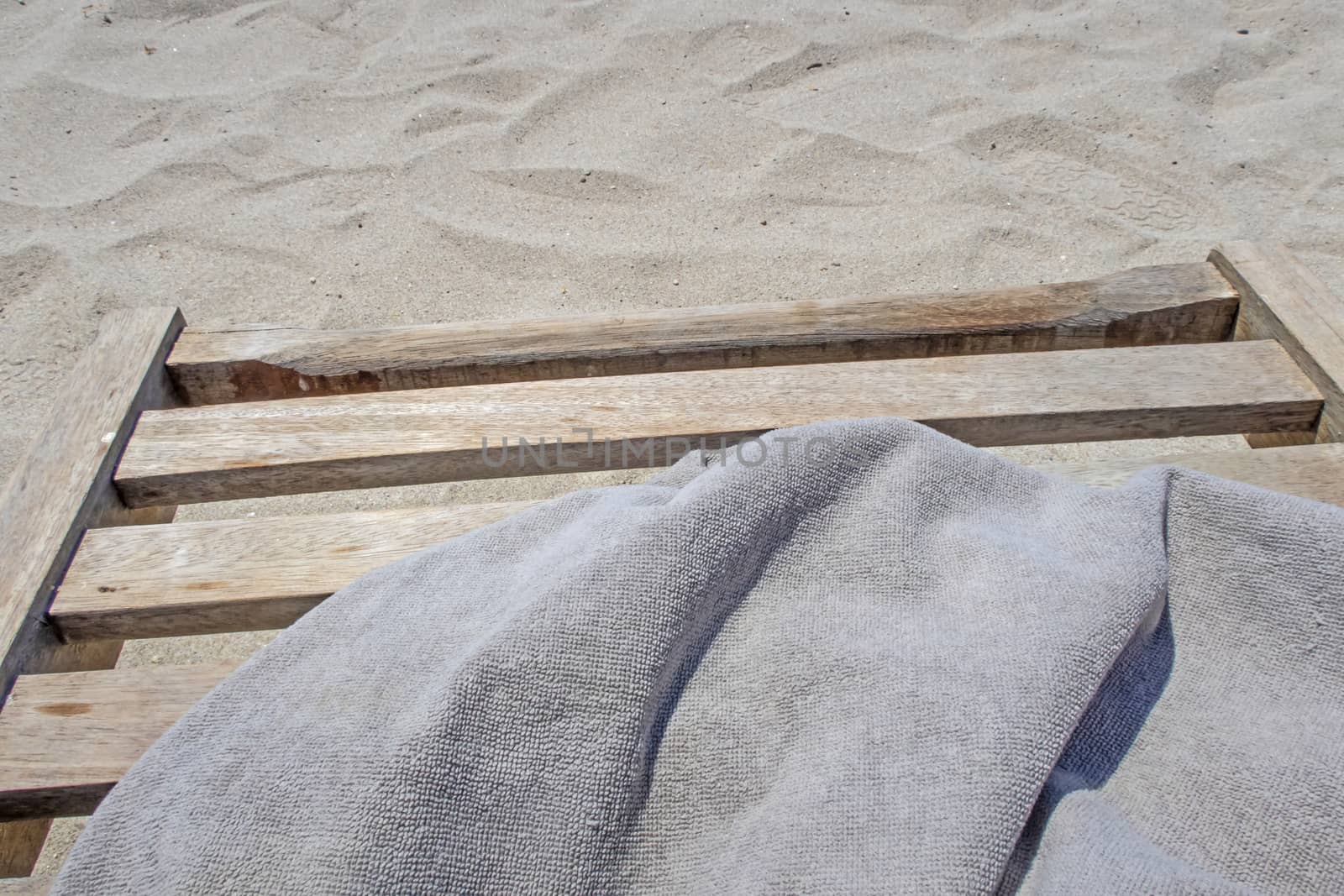 wooden sun lounger chair for sunbathing on the beach