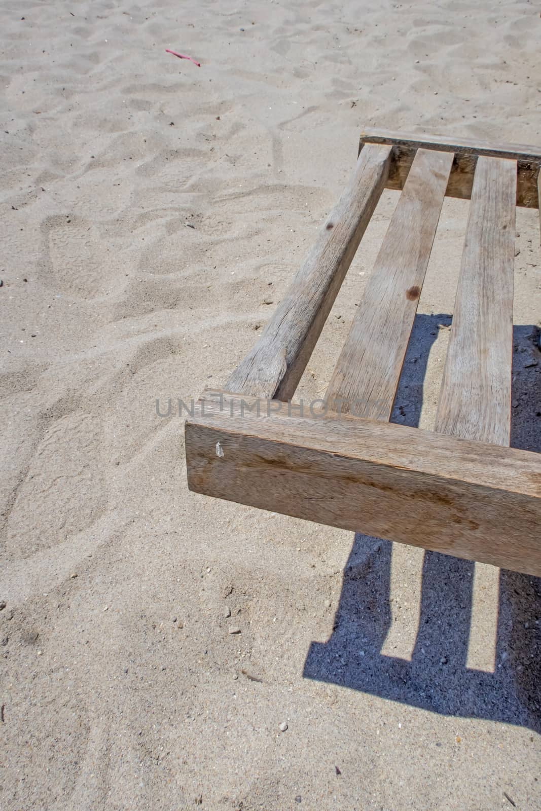 wooden sun lounger chair for sunbathing on the beach