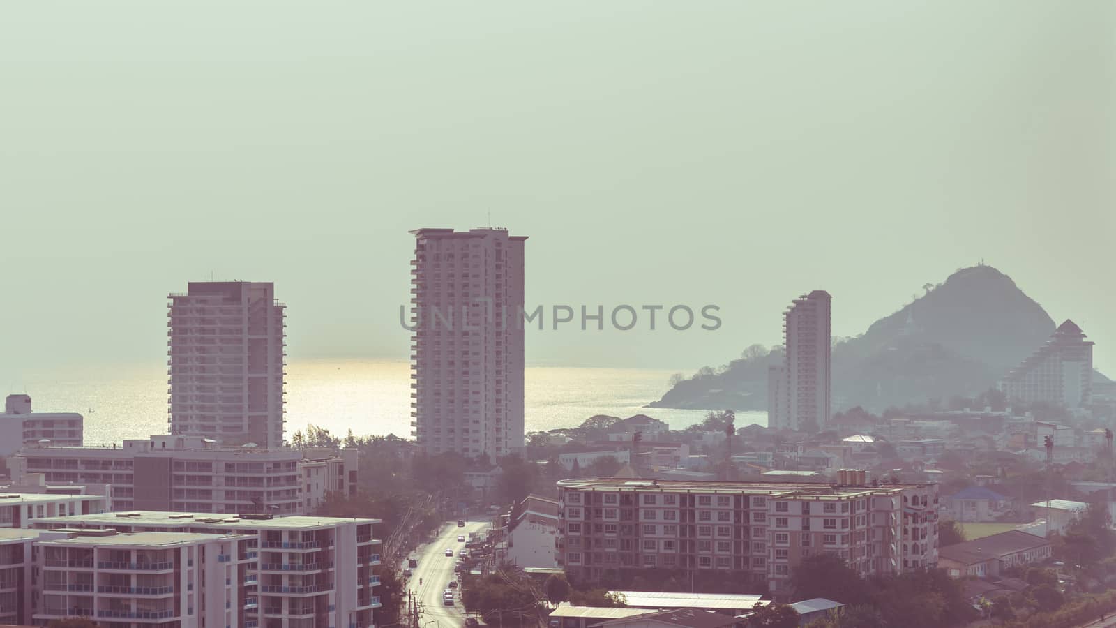 aerial view of small city by the sea in morning sunlight with reflection on water