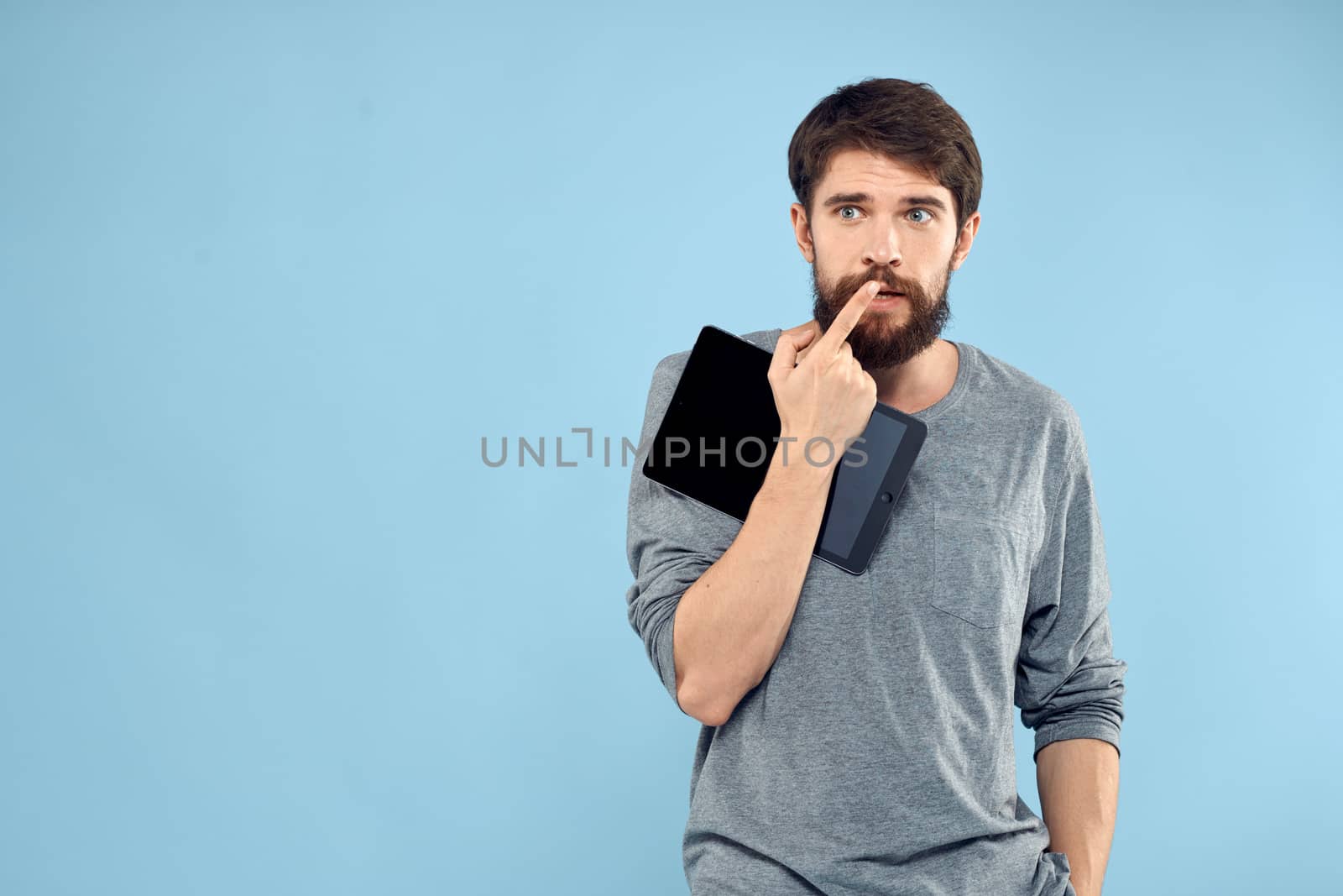 Man with tablet in hands technology lifestyle wireless device blue background. High quality photo