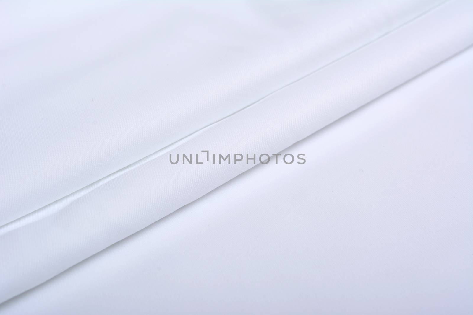 white Knitted elastic fabric, weaving of threads texture, crumpled fold. For underwear, sports clothes and swimwear. Space for text.