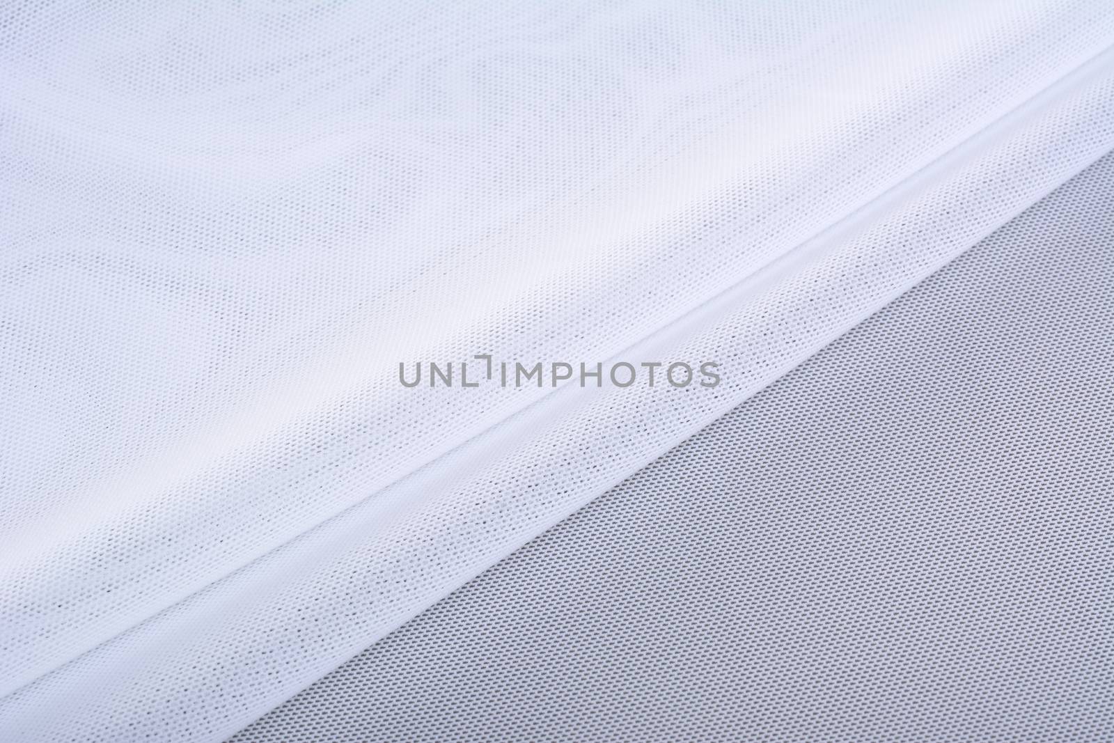 white Knitted elastic fabric, weaving of threads texture, crumpled fold. For underwear, sports clothes and swimwear. Space for text.