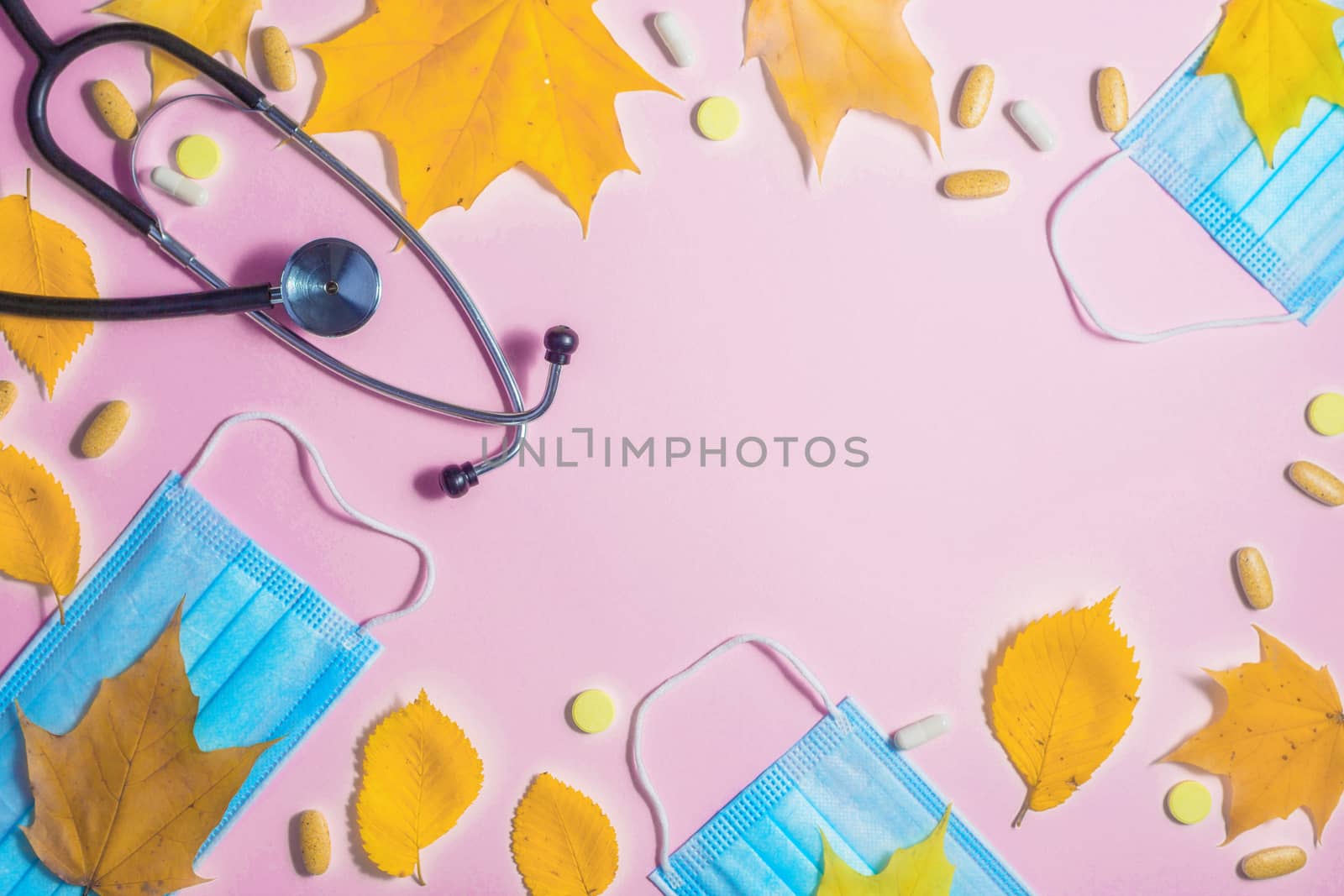 Autumn fallen leaves and medical masks and medicines on black background.