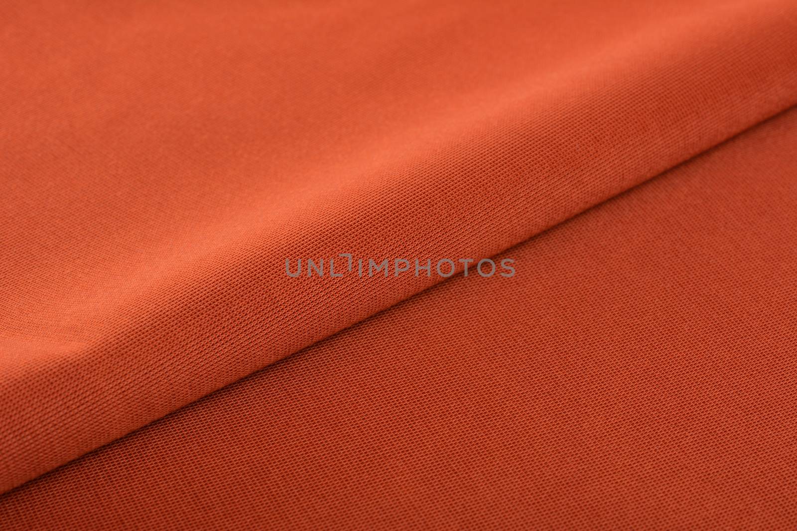 orange Knitted elastic fabric, weaving of threads texture, crumpled fold. For underwear, sports clothes and swimwear. Space for text.