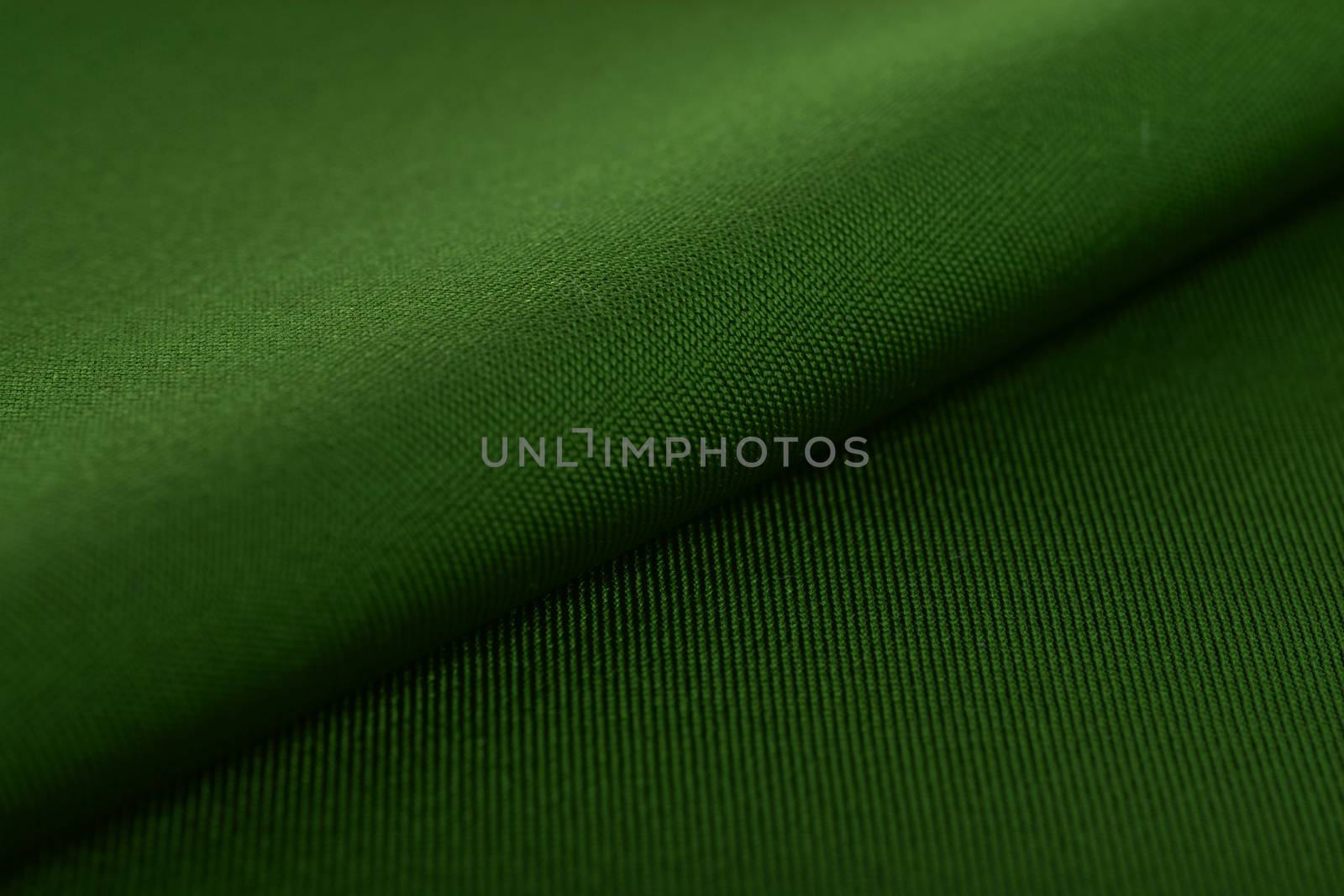 green Knitted elastic fabric, weaving of threads texture, crumpled fold. For underwear, sports clothes and swimwear. Space for text.