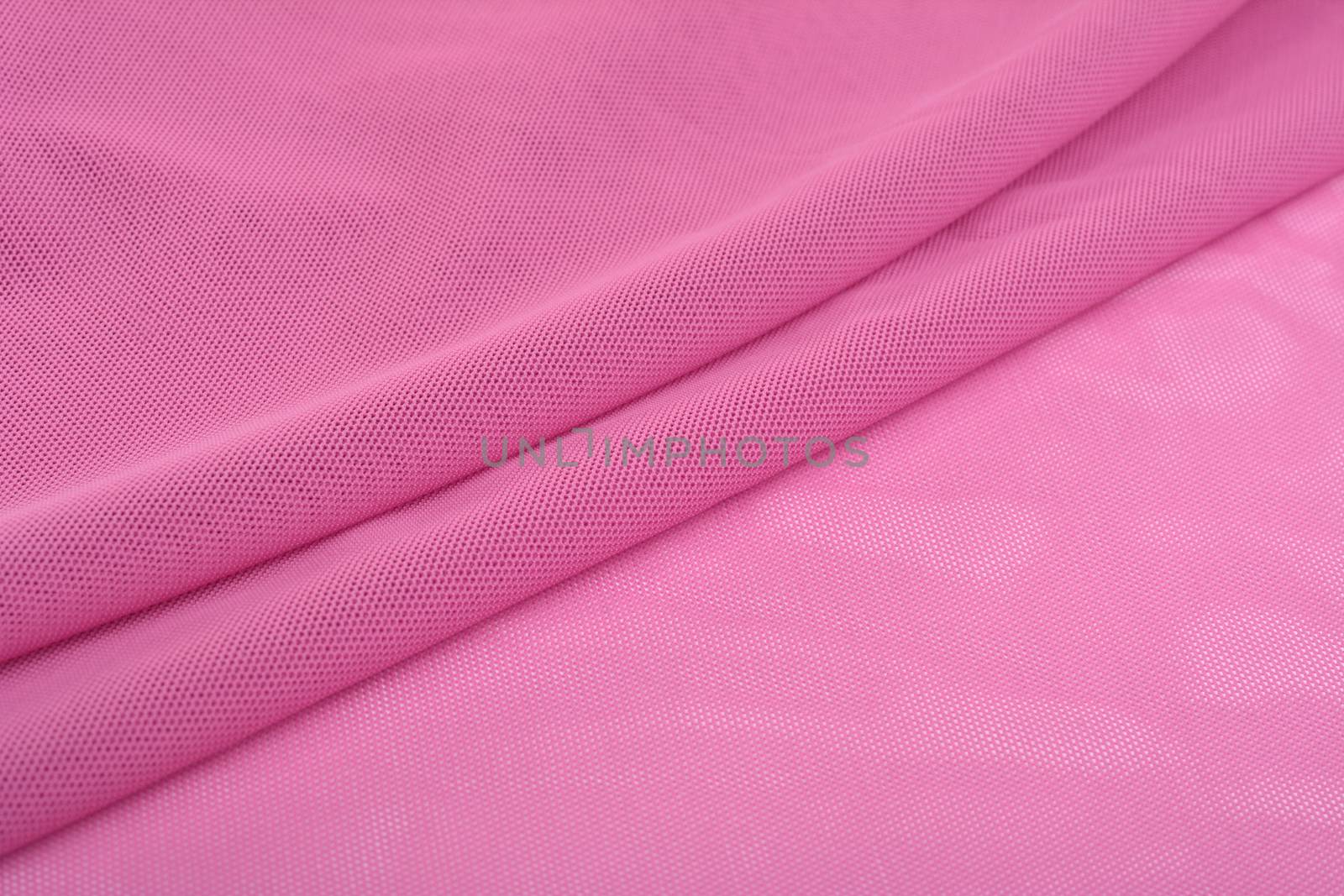 pink Knitted elastic fabric, weaving of threads texture, crumpled fold. For underwear, sports clothes and swimwear. Space for text.