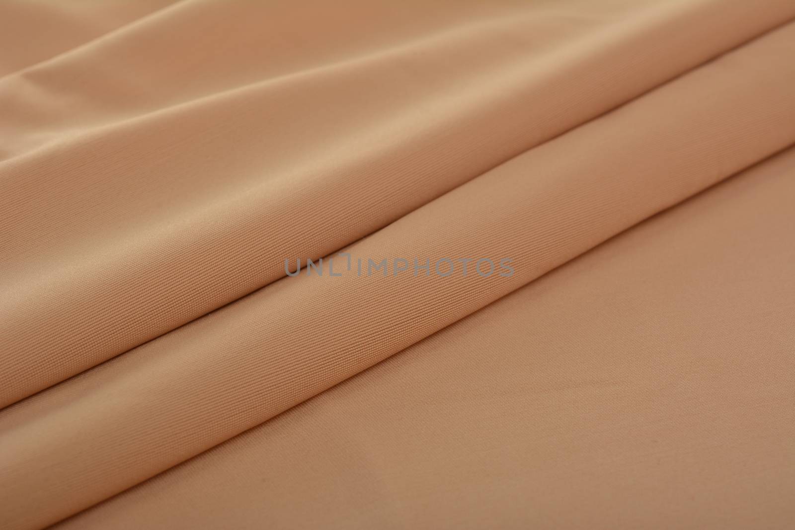 beige Knitted elastic fabric, weaving of threads texture, crumpled fold. For underwear, sports clothes and swimwear. Space for text.