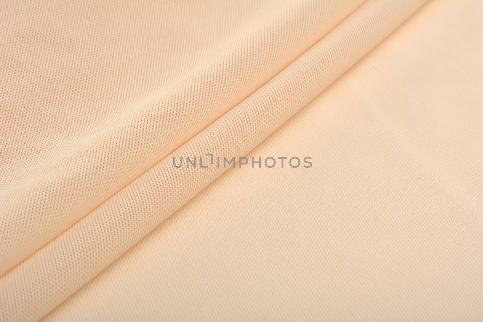 beige Knitted elastic fabric, weaving of threads texture, crumpled fold. For underwear, sports clothes and swimwear. Space for text.