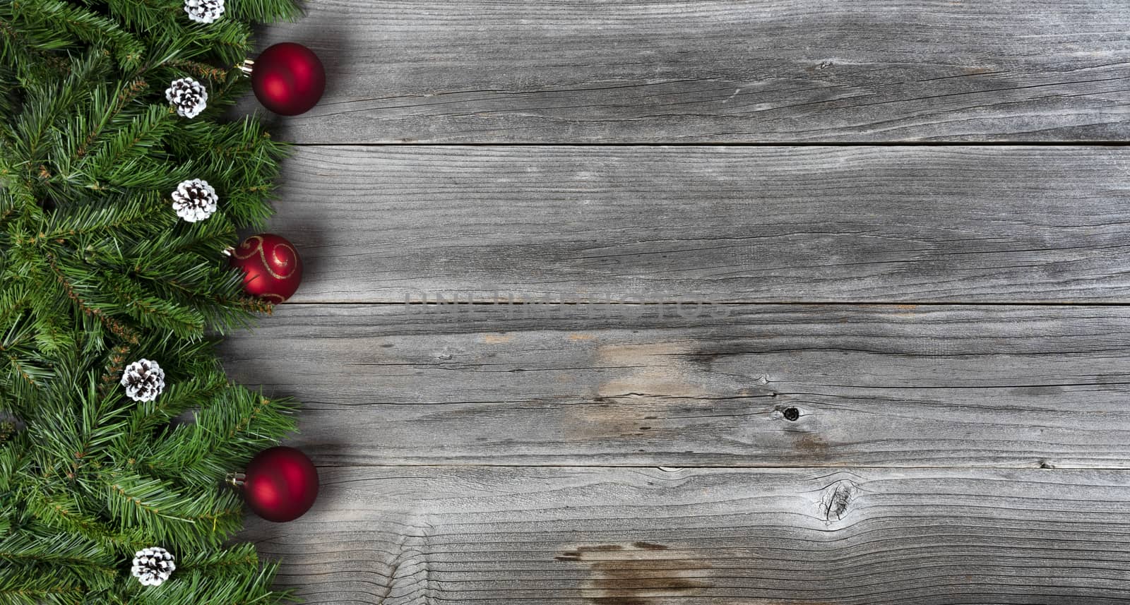 Merry Christmas and Happy New Year holiday concept with decorations on left side of rustic wooden boards