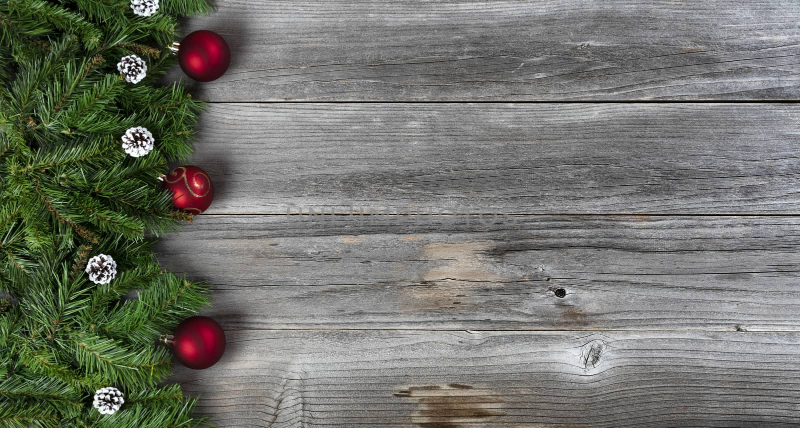 Merry Christmas and Happy New Year holiday concept with decorations on left side of rustic wooden boards