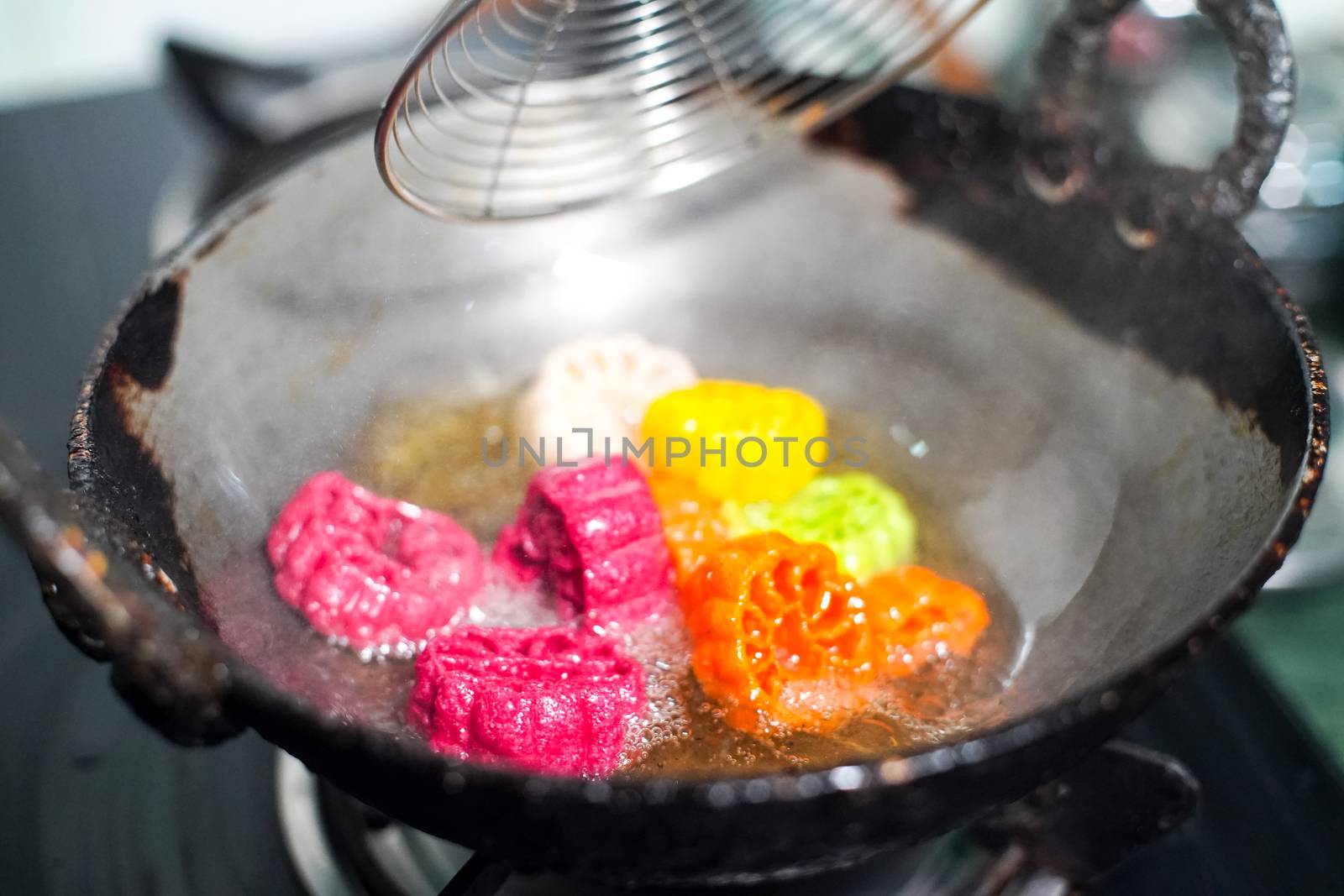 shot of colorful Fryums being deep fried in hot oil bubbling and sizzling with bubbles forming and size increasing of this popular north indian snack and street food. This sago and potato starch delicacy is a popular snack that is unhealthy but very tasty