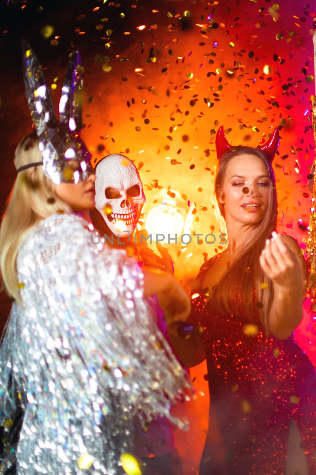 Happy people men and women mixed race dancing together on Halloween party