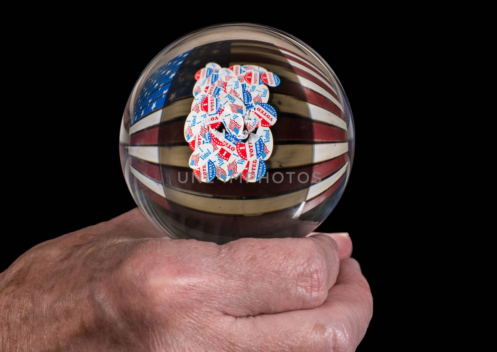 Senior caucasian man's hand holding glass fortune tellers globe or ball to predict the result of the USA presidential election