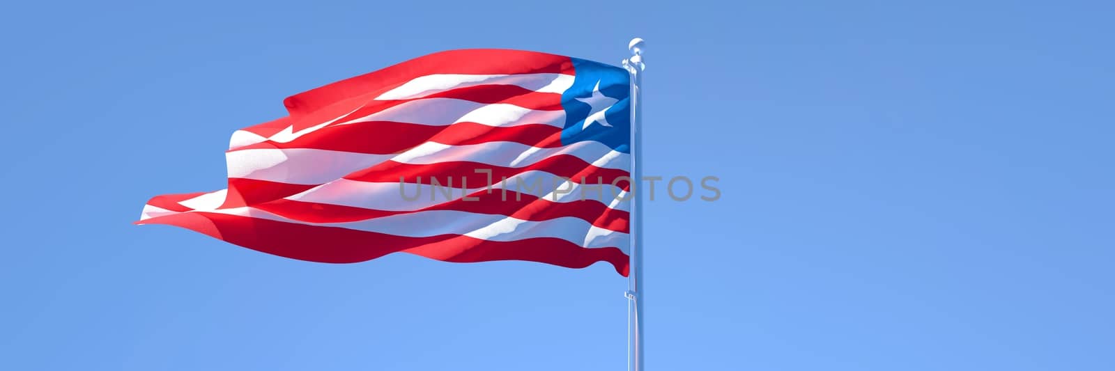 3D rendering of the national flag of Liberia waving in the wind against a blue sky