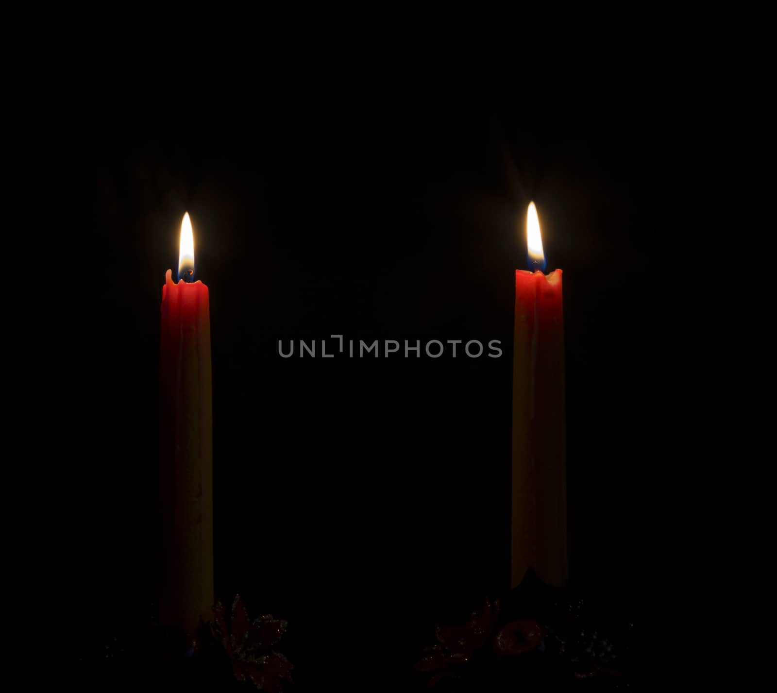 Two candles burning in the dark