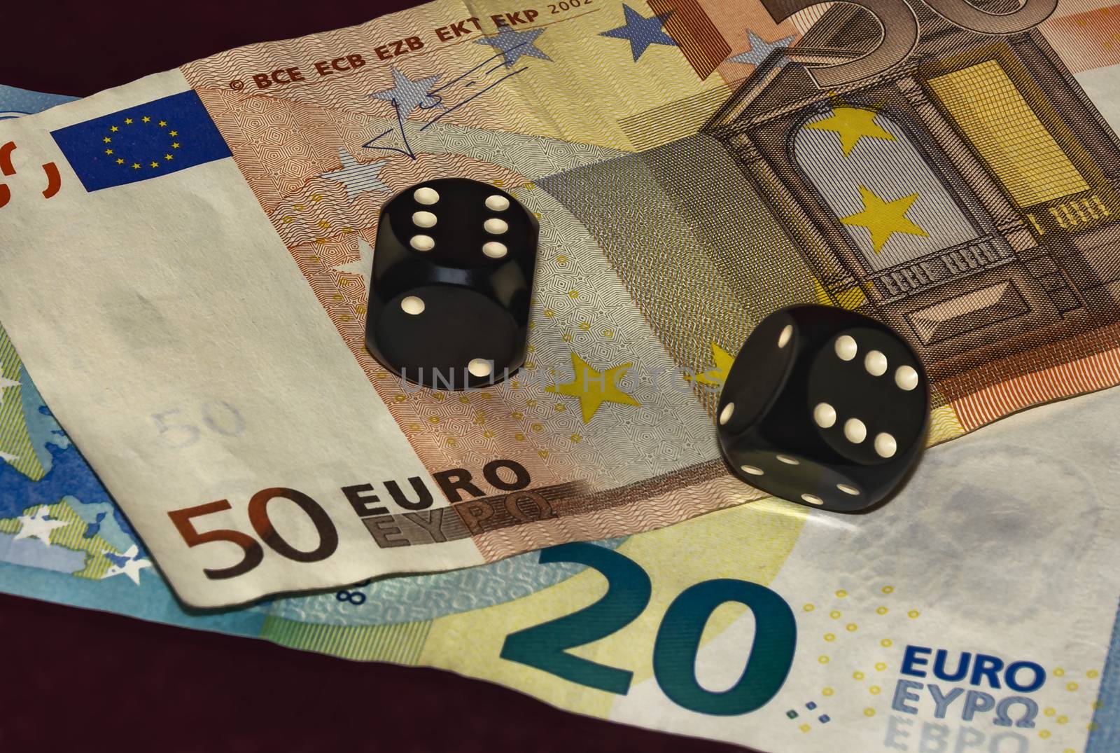 On a red cloth of the visible bills twenty and fifty euros. On the bills are black cubes for poker