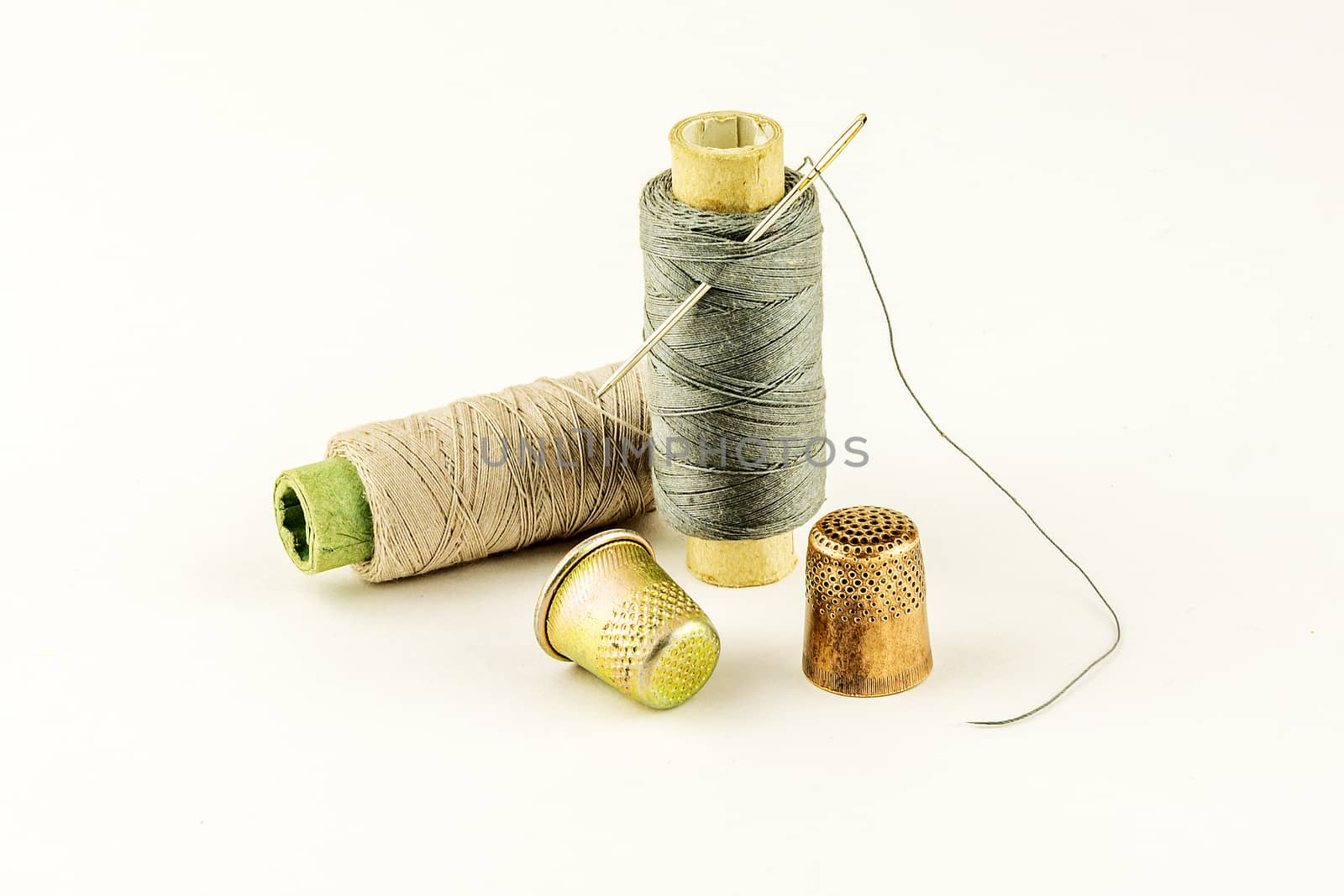 Two spools of thread with a needle and a thimble for sewing two by Grommik