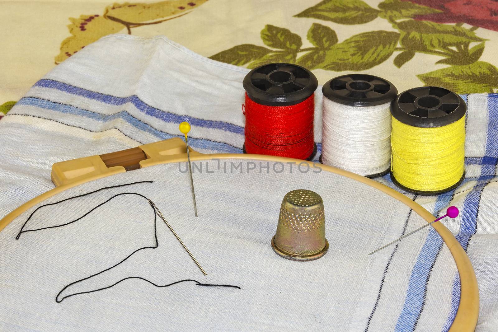 The material in the embroidery frame with a needle, tailor's pin by Grommik