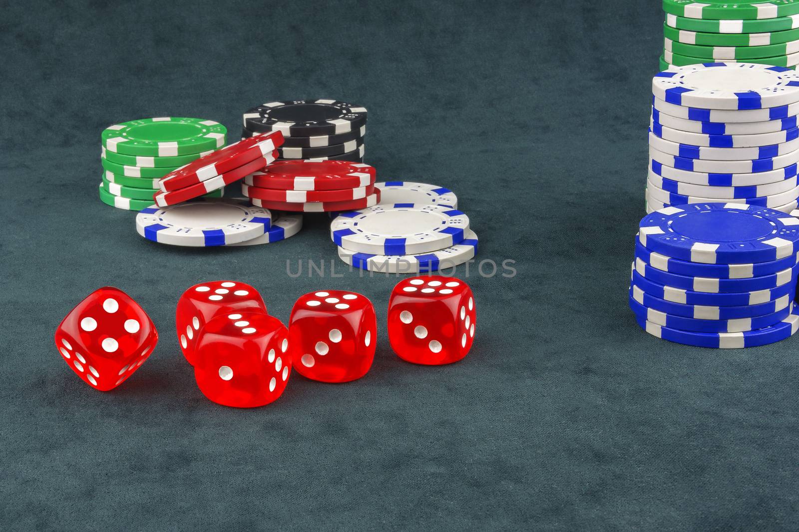 On the green cloth are casino chips and dices for playing poker by Grommik