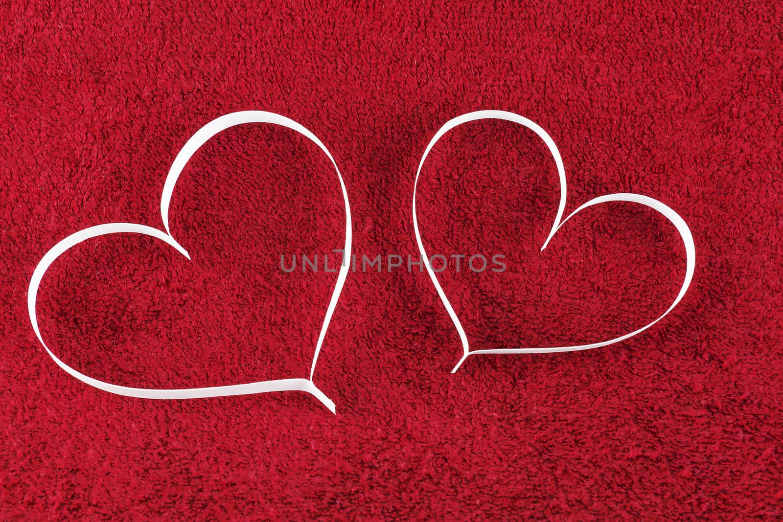 On the red surface are two paper heart silhouette