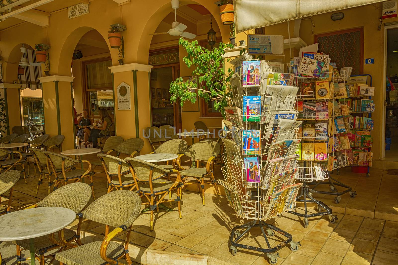 Stand with books and magazines is in the coffee away from the tables