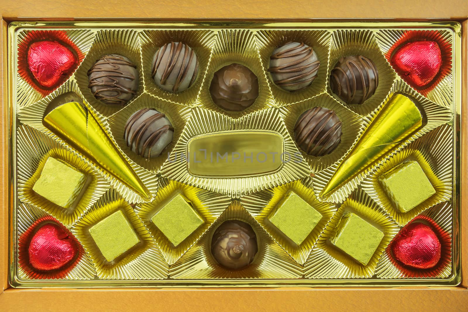 Chocolates of different types lie in the open box by Grommik