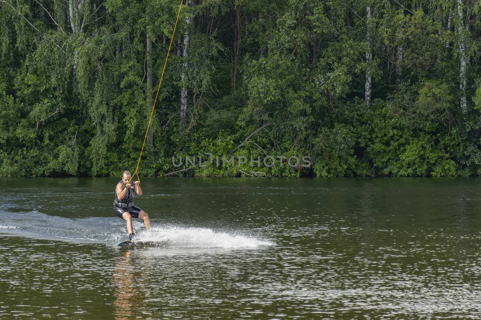 The man trains to balance on the board for kitesurfing by Grommik