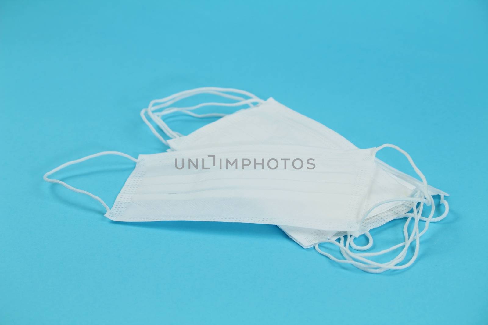 Disposable Medical masks on blue background. Covid-19 and healthcare concept