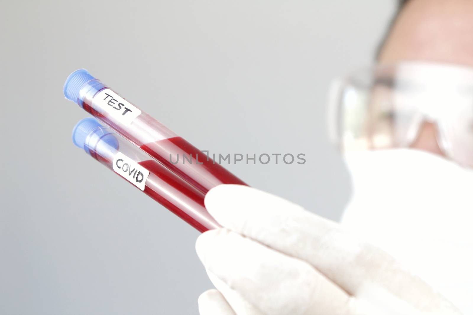 Laboratory assistant holding test tube of covid-19 virus by soniabonet
